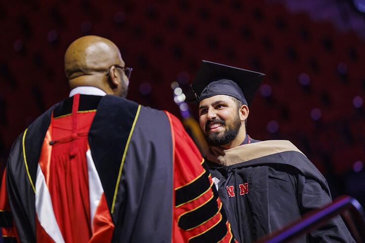 Alex Fernando shakes hands with Chancellor Rodney Bennett after being given his MBA diploma on Dec. 15, 2023.