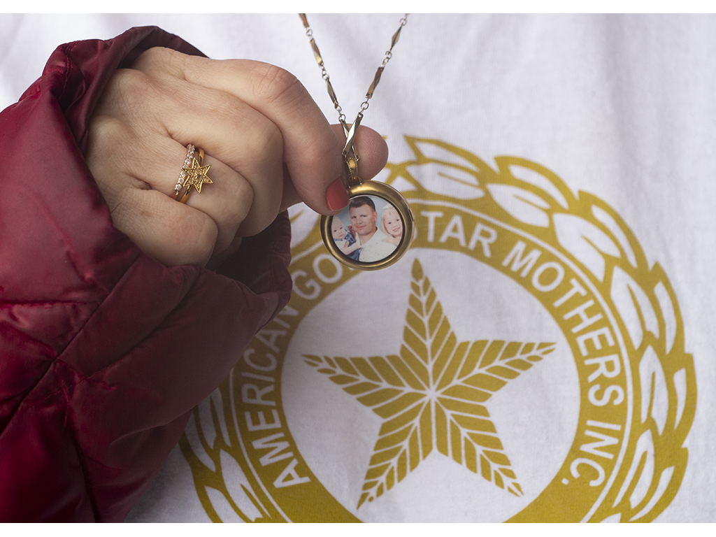 woman holds gold star locket