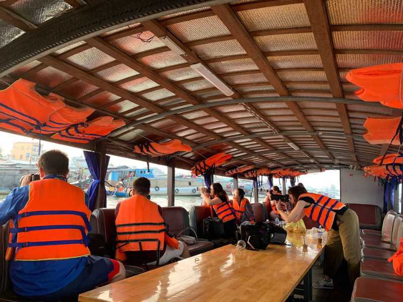 Students take photographs on the Mekong river in Vietnam during the 2023 Global Eyewitness trip. 