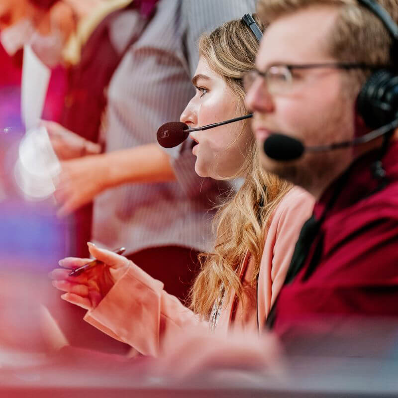 Students announcing a basketball game courtside