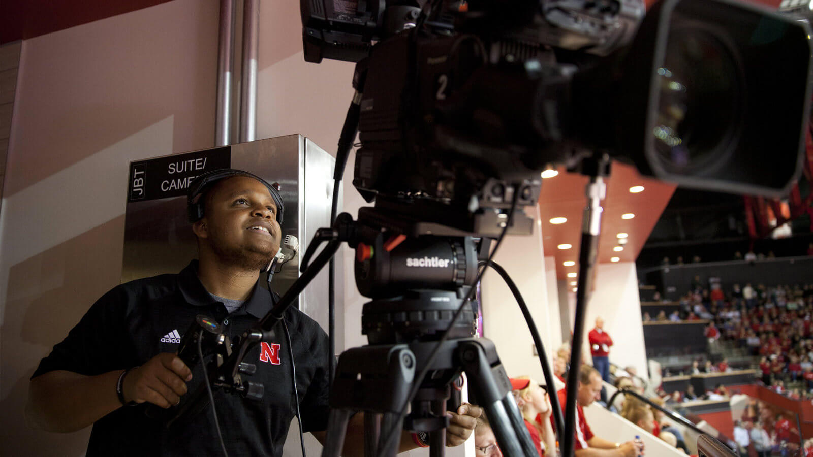 Student looking through camera monitor at sporting event