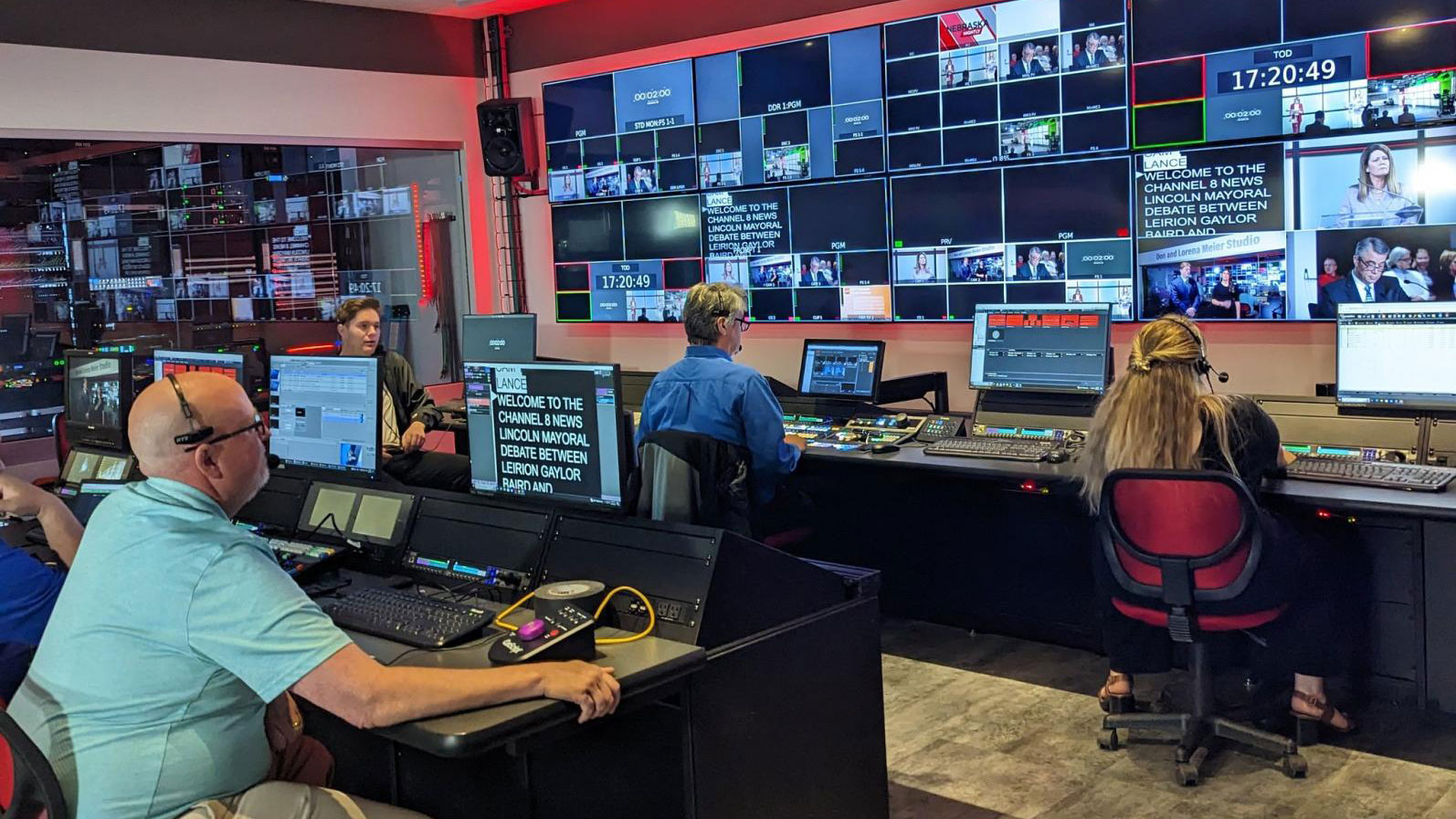 Students and staff running the behind the scenes monitors of a news show.