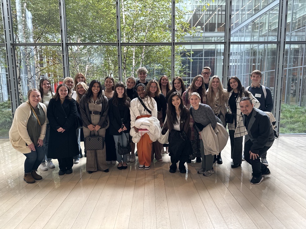 Group of people stand in front of large window