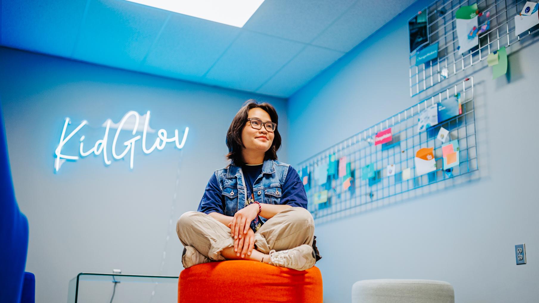 woman sits on a stool in an office