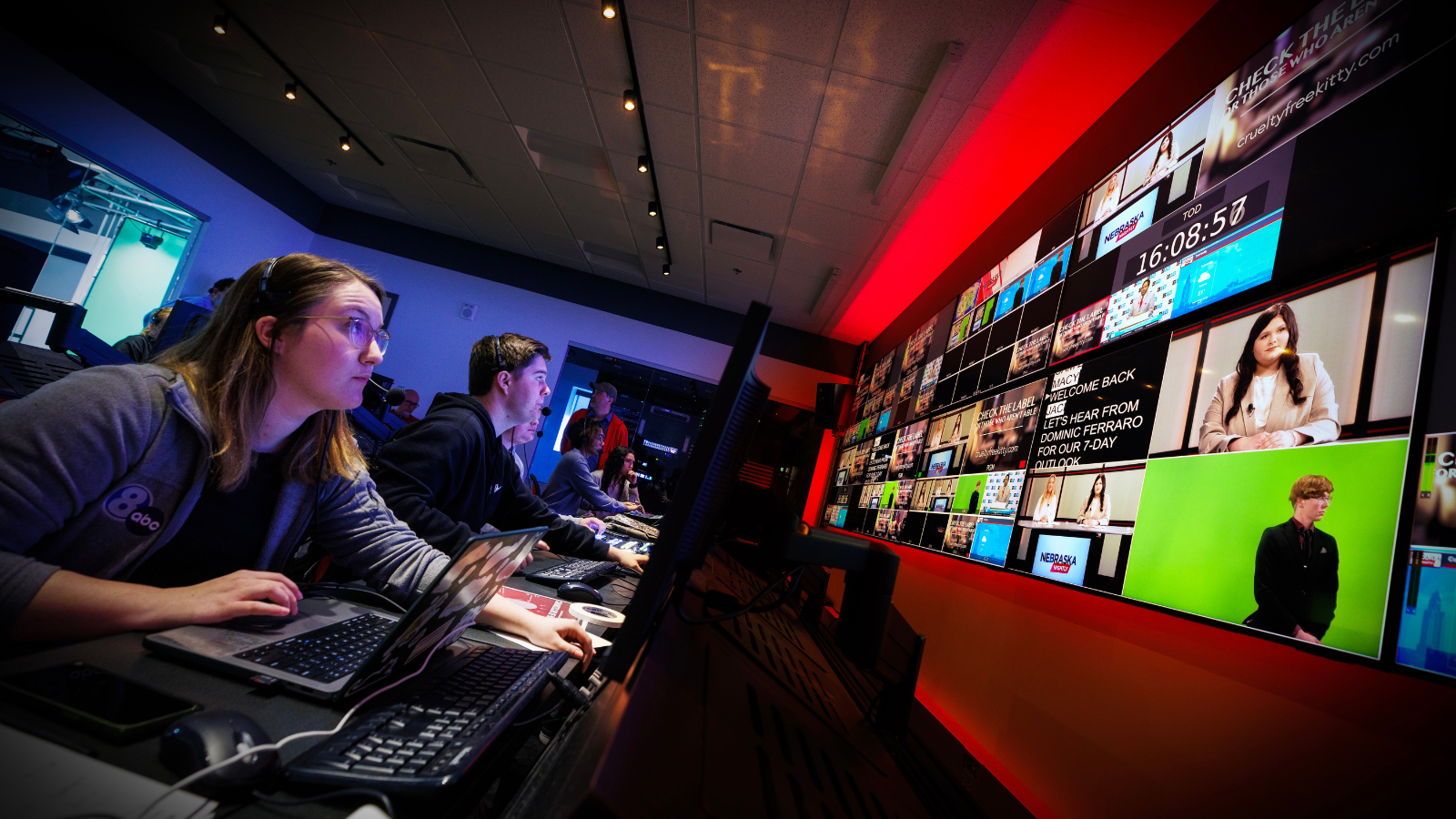 Students look up at screen in a television studio control room