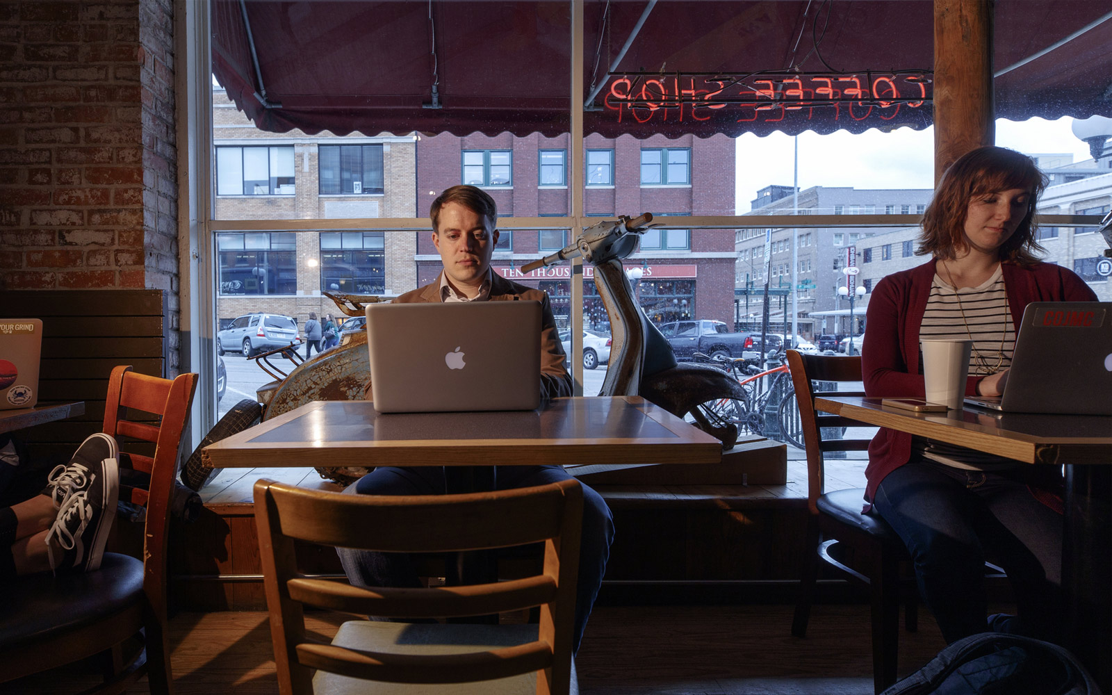 Man works at a computer in a coffee shop