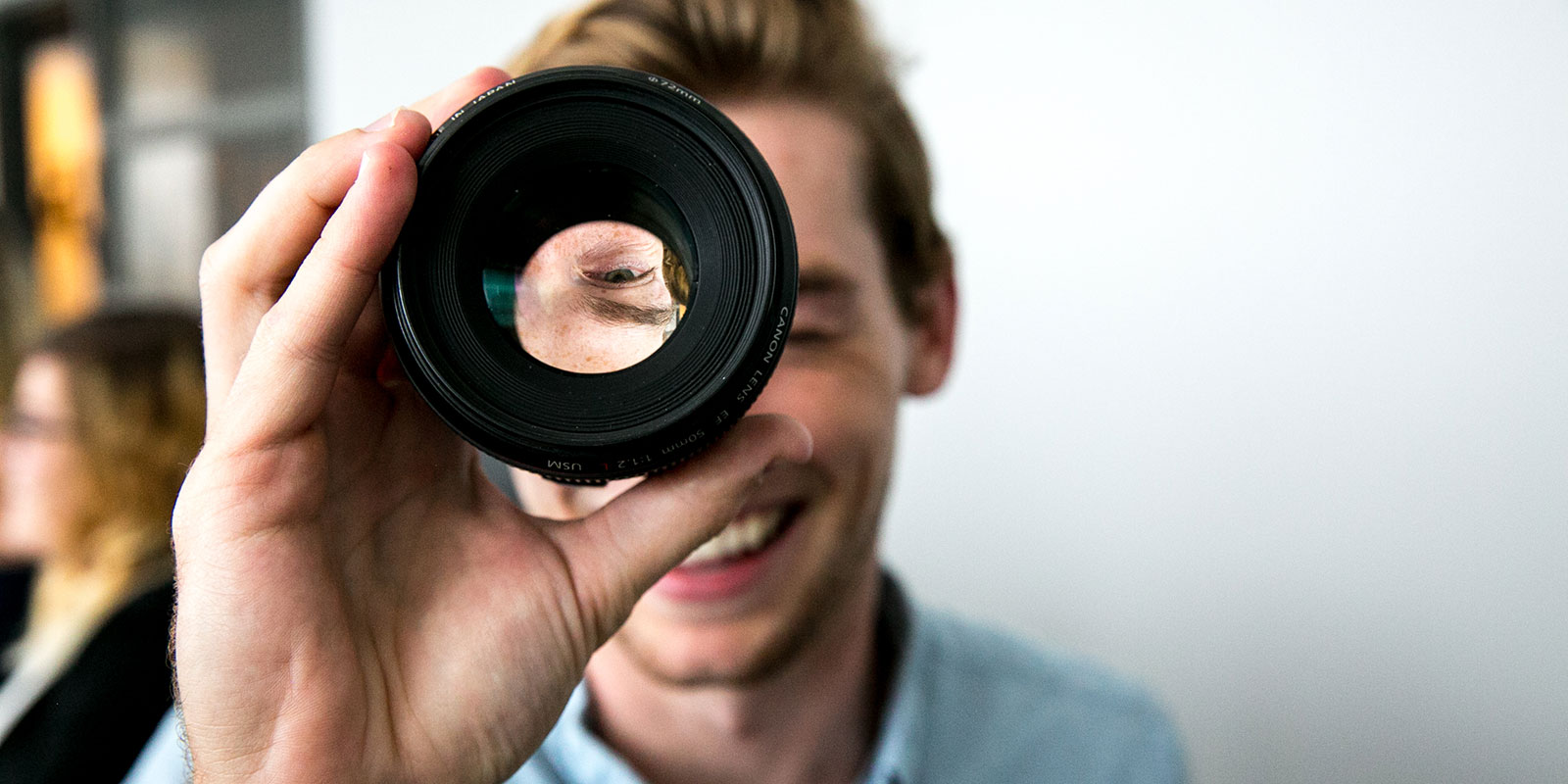 Man looks through a camera lens