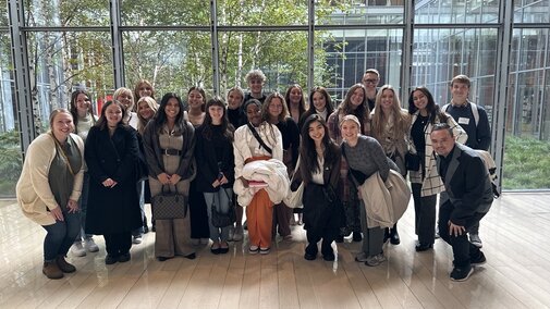 Group of people stand in front of large window