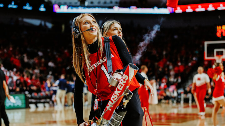 Ashley Beckman works the T-shirt machine on the court during a Husker Basketball game