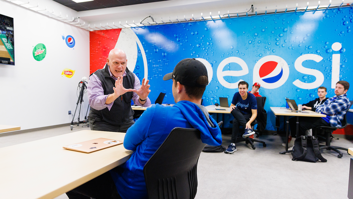 John Shrader gestures as he talks about describing great defense in a basketball game during his BRDC 375 - Sports Broadcasting course in the UNLimited Sports multimedia classroom in Andersen Hall.
