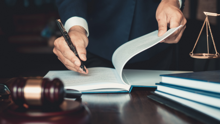 man writing next to scales of justice