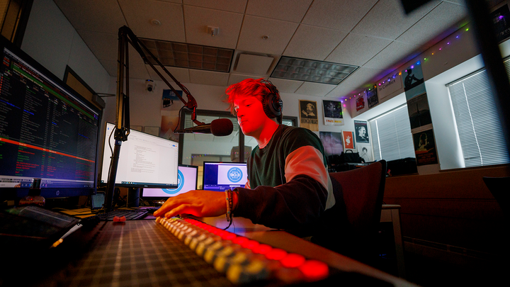 Man talks into a mircrohone in a radio station