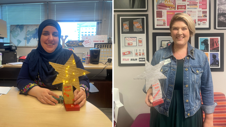 Two people holding star shaped awards 