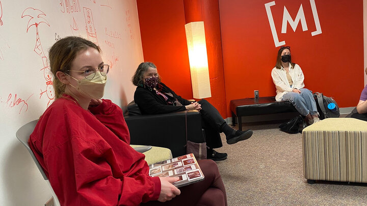 people sit in small conference room. 