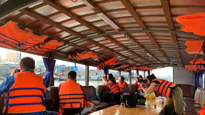 Students take photographs on the Mekong river in Vietnam during the 2023 Global Eyewitness trip. 