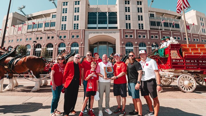 Huskers, including Athletic Director Troy Dannen (middle), standing outside Memorial Stadium during the Budweiser Clydesdale event. Brandon Meier (far right) is Senior Associate Athletic Director of Marketing and Multimedia.