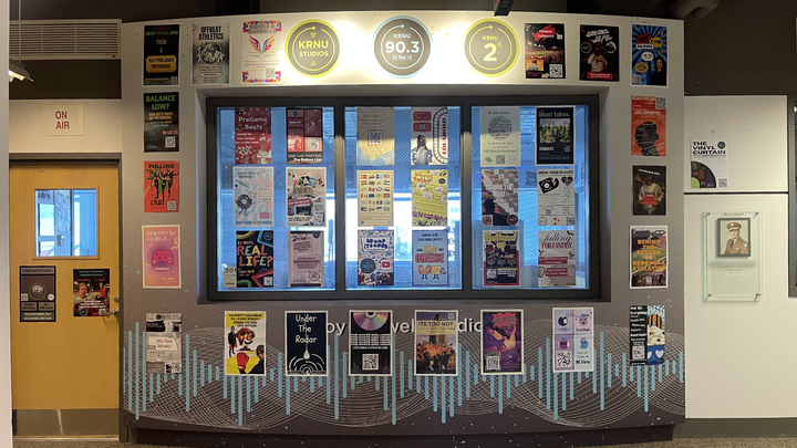 outside the krnu radio station with windows covered in posters promoting shows.