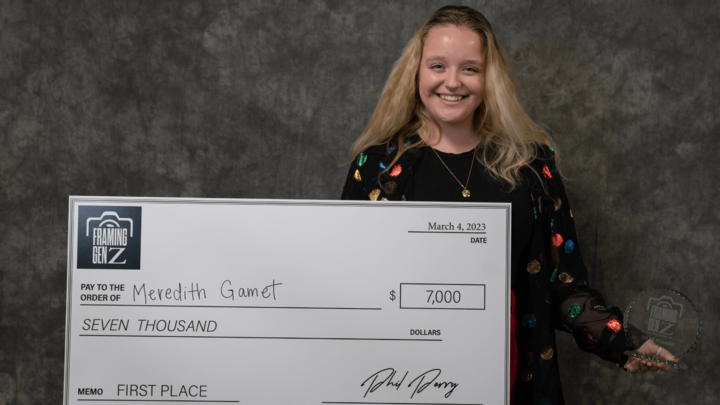 Meredith Gamet holding a big check from the Perry Photo Challenge.