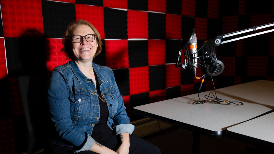Kelli Boling, seen here in the podcast studio in Andersen Hall, is the co-author of new research highlighting the impacts of true crime media on the family and friends of crime victims.