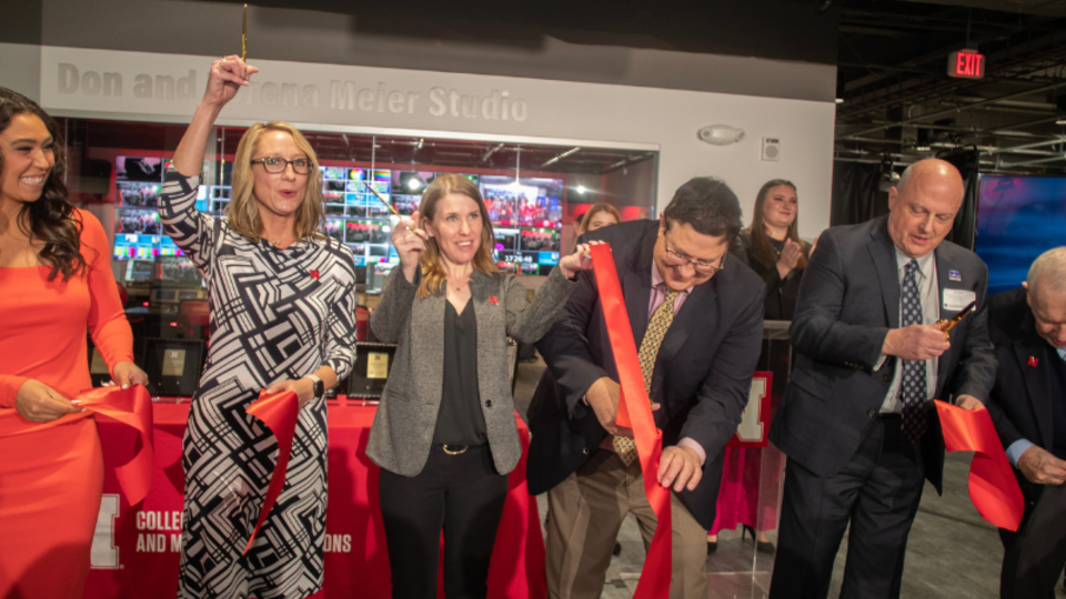 people cutting a red ribbon