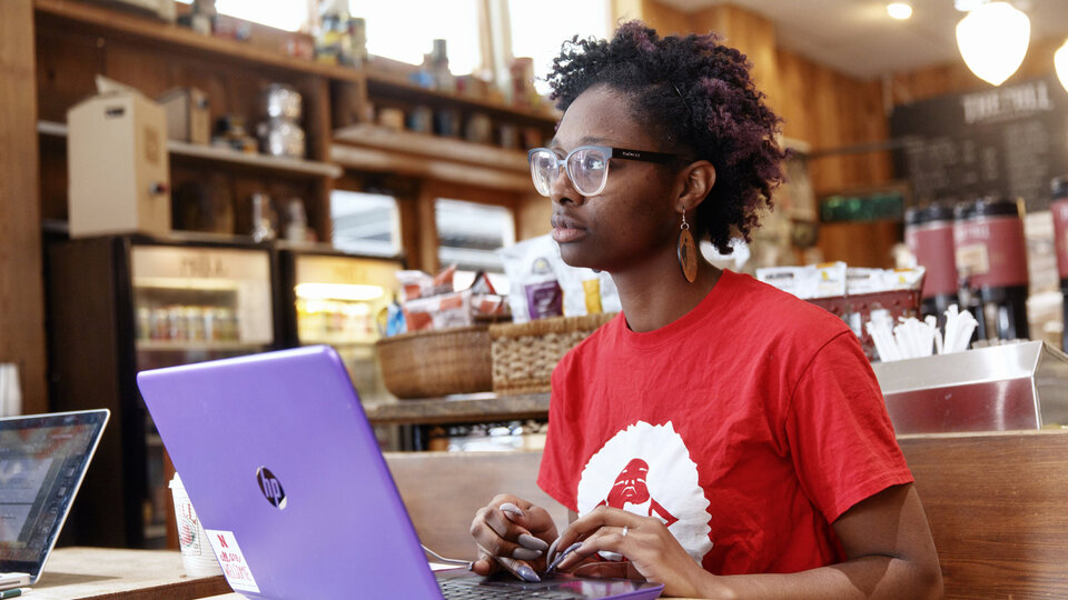 Woman works computer in a coffee shop