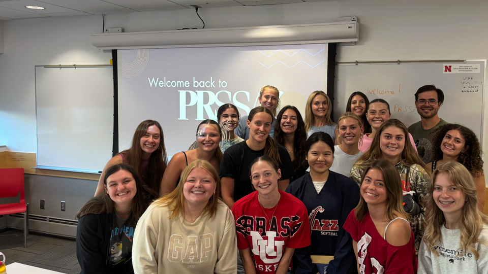 Smiling group of students posing in a classroom setting