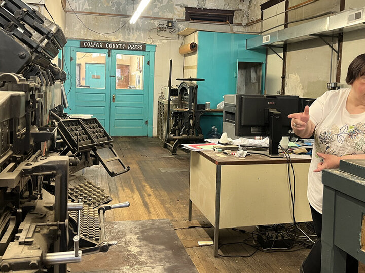 Women stands in front of printing press