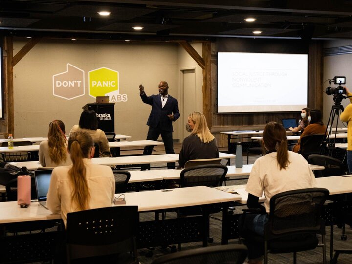 Man stands in front of classroom pointing up