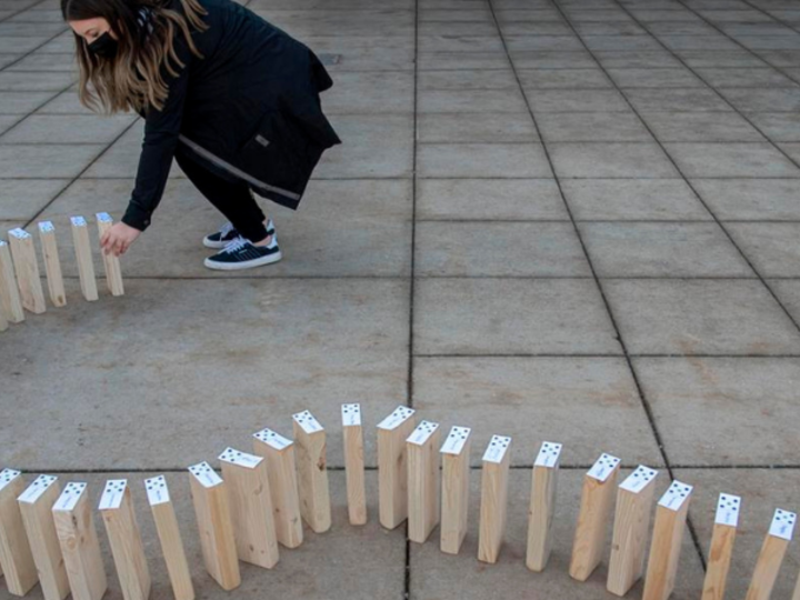 Someone setting up dominoes