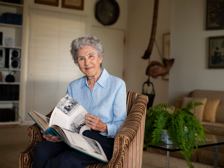 Woman sits in a chair flipping through a book