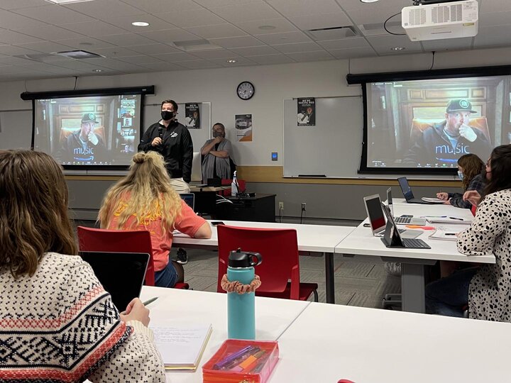 Students listen to speaker apeparing via Zoom in class