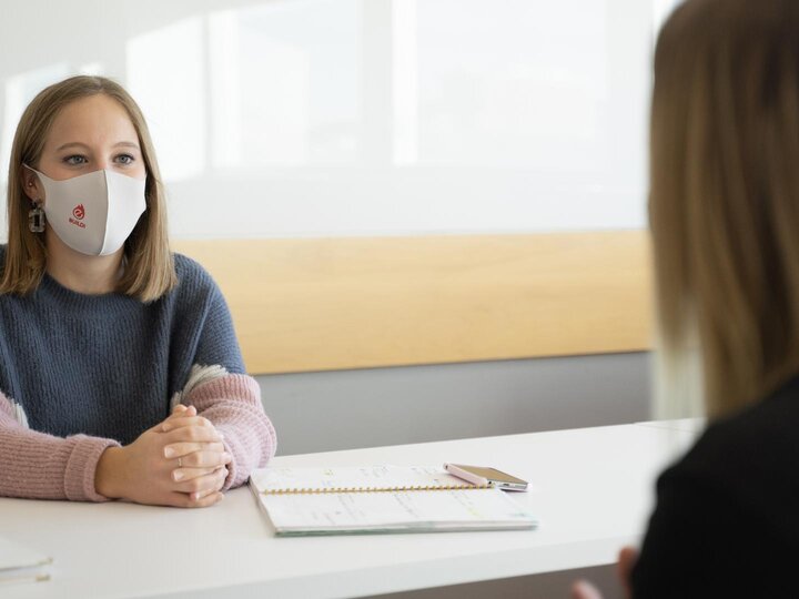 Two women sit at a table and talk 