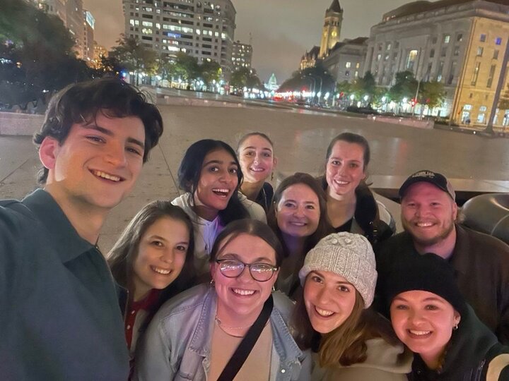 Group of students stands on a a street at night