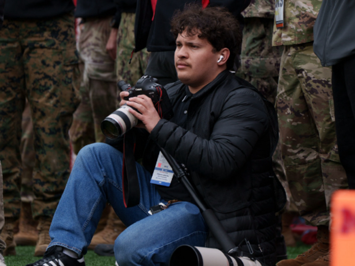 Man kneels and prepares to take a photograph