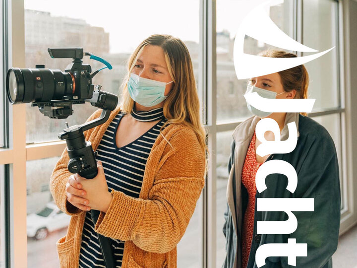 Two women look through a camera