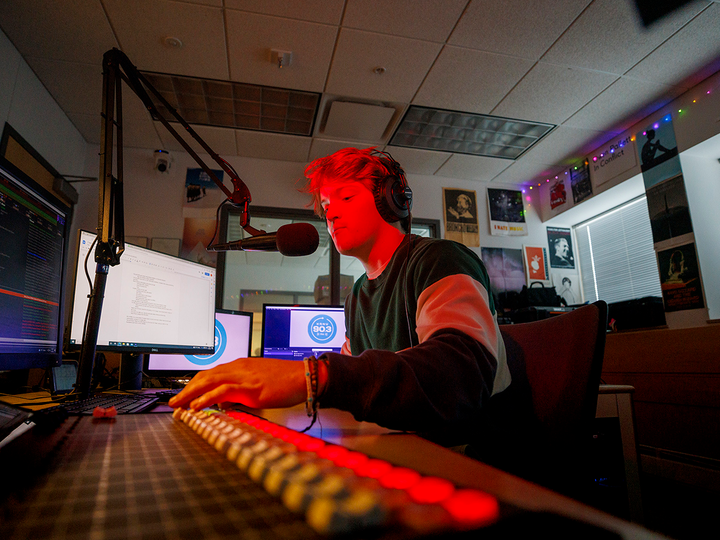 Man talks into a mircrohone in a radio station