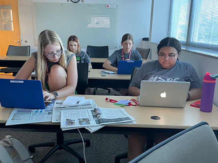 Students seated at desks with their laptops open