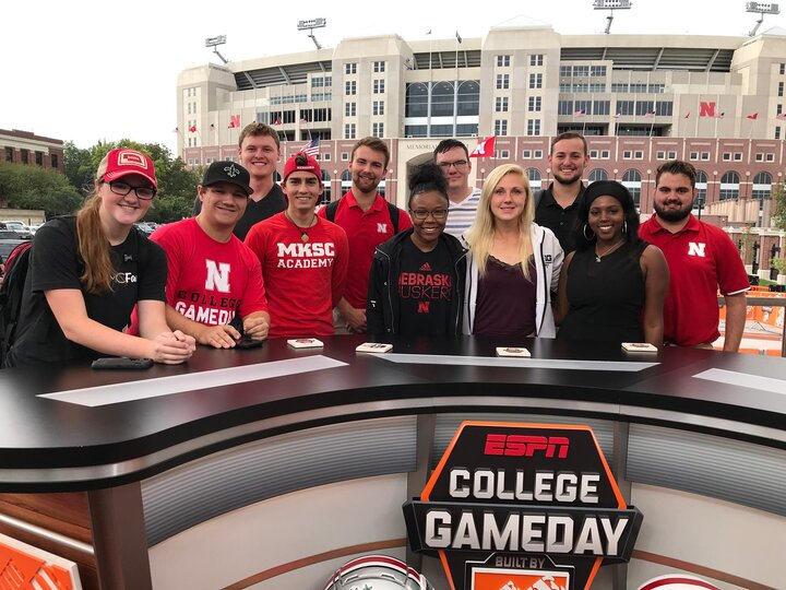 Group of students stands behind an ESPN set in front of a football stadium