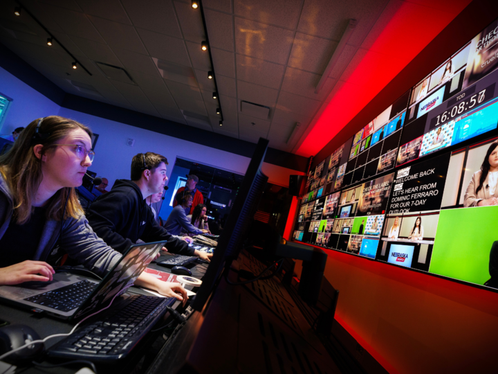 Students look up at screen in a television studio control room