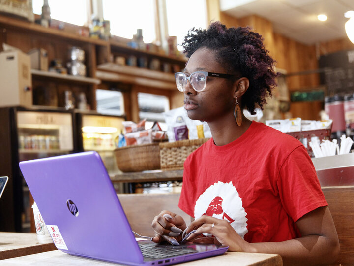 Woman works computer in a coffee shop