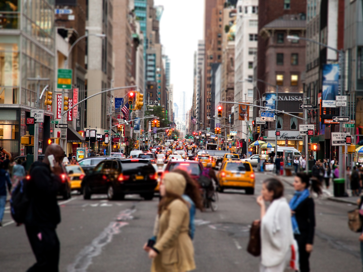 Busy urban street filled with cars and people 