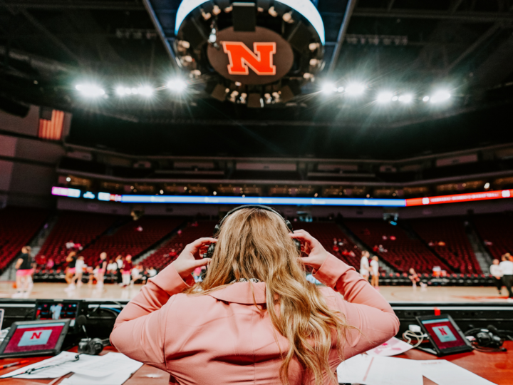 student putting on headphones in arena