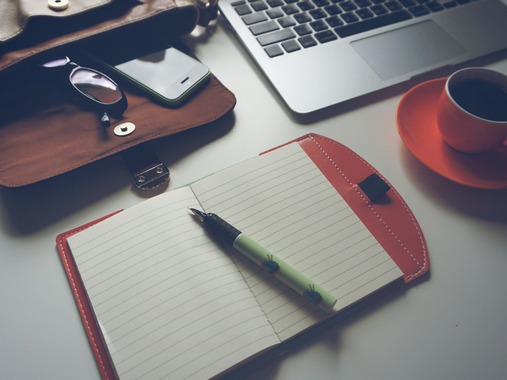 note pad and coffee cup witting on desk