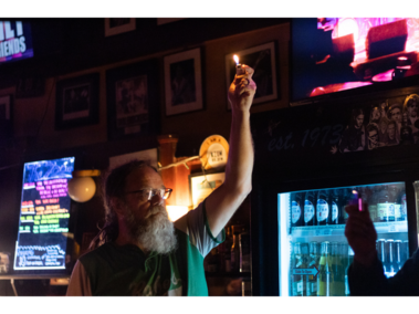 Bartender enjoys Sailing in Soup’s performance at the Zoo Bar David Rabe, 57, of Lincoln, holds up a lighter during Sailing in Soup’s performance at the Zoo Bar on Saturday, Feb. 21, 2026, in Lincoln, Nebraska. Rabe is a bartender at the Zoo Bar and hosts The Slacker Morning Show at 89.3 KZUM Community Radio. (Photo by Alex Gryczanowski / UNL College of Journalism and Mass Communications)