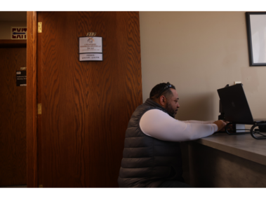 3.	Setting up: Clifton Hobbs adjusts his computer cords after unpacking new supplies on Feb. 21, 2026. Clifton expanded his counseling and pastoral services to Lincoln from Bellevue after finding success in both fields. “Obviously not everybody is necessarily a believer; I will tell my clients I am a pastor, but I don’t impose values in sessions. I find it helps them feel safe if they want to talk about it,” Clifton Hobbs said. (Photo by Amanda Yuan)
