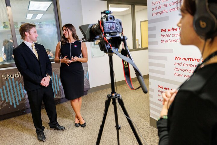 Damon Bennett, left, and Alaina Tomesh speak in front of the camera inside Andersen Hall.