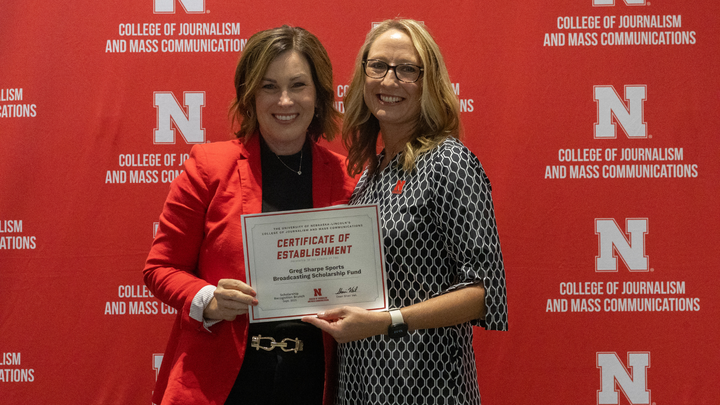 Amy Sharpe receives a Certificate of Establishment for the Greg Sharpe Sports Broadcasting Scholarship Fund.