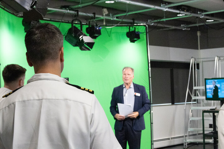 Barney McCoy instructing sailors in front of green screen