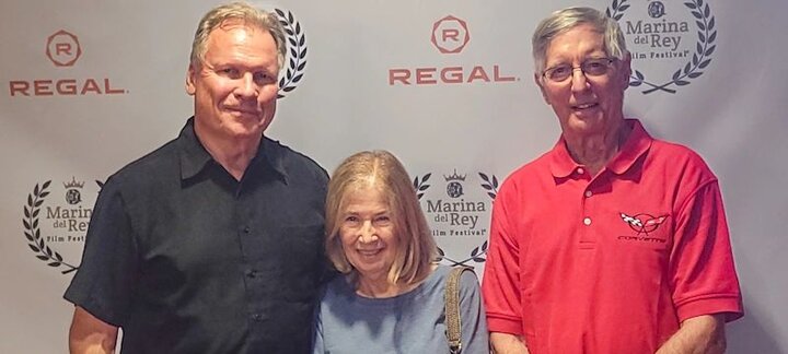 Three People stand infron of a backdrop