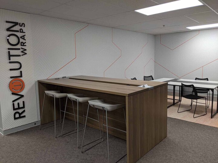 Wood conference table next to a grey and orange striped wall